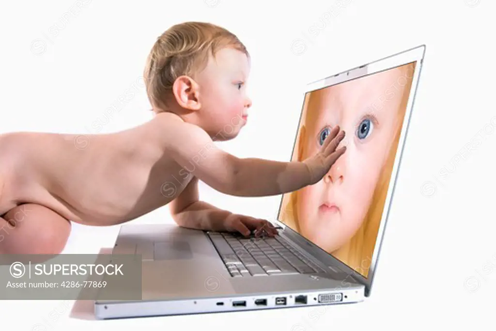 BABY PLAYING WITH LAPTOP COMPUTER.