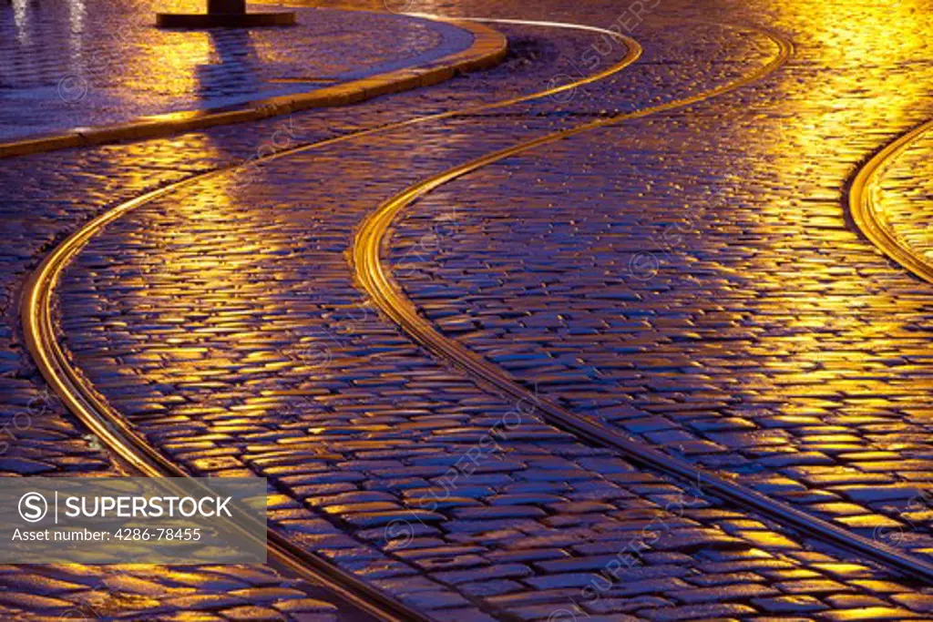 prague - tram tracks and cobblestone street at dusk after rain