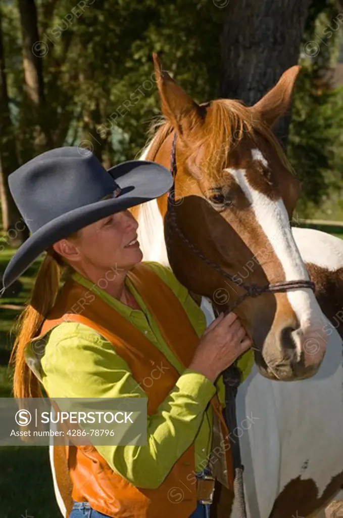 Woman prepping horse for ride