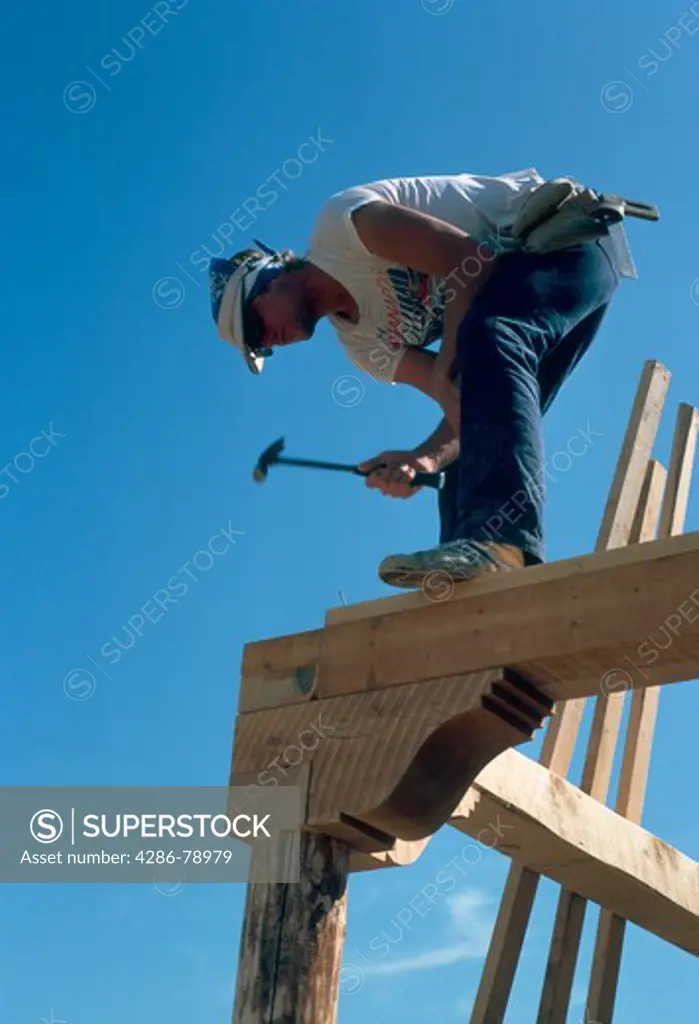 Construction worker standing on frame of a custom house