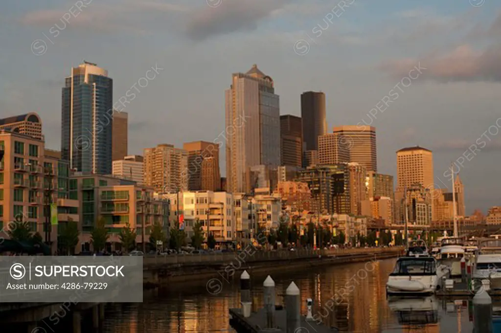 Seattle skyline and Pier 66 illuminated at sunset with tourists sightseeing along the Seattle waterfront Washington State USA