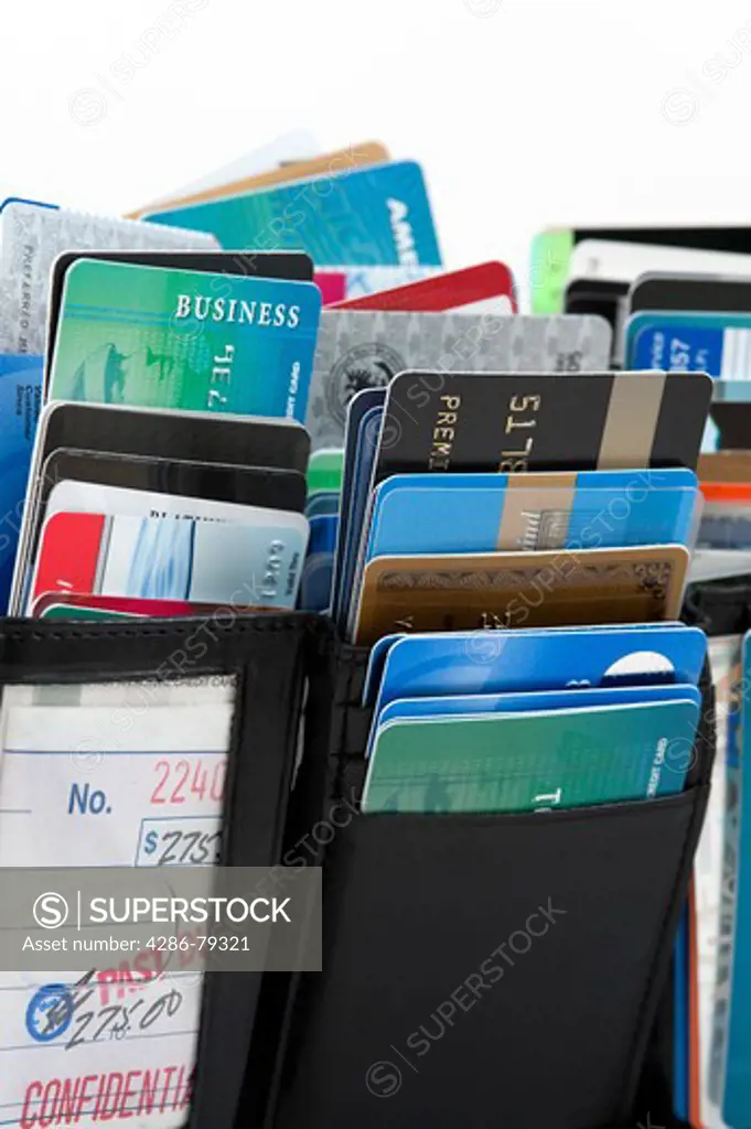 Wallet stuffed with credit cards on a white background studio image