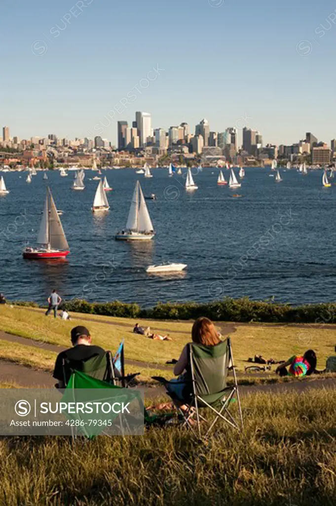 People picnicking at Gas Works Park while enjoying the Duck Races on Lake Union with Sailboats and Seattle Skyline Seattle Washington State