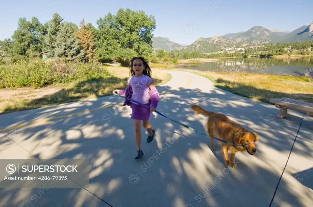 Chinese-American girl with her golden retreiver on a walk