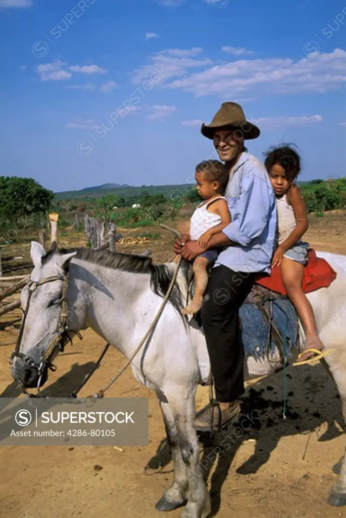 Father on horseback with two children, Brazilian Highlands, Goias, Brazil