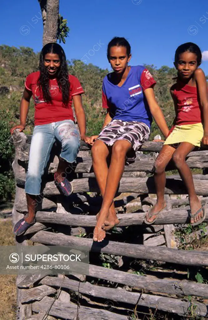 Country girls sitting on corral fence, Chapada da Piteira, Brazilian Highlands, Goias, Brazil