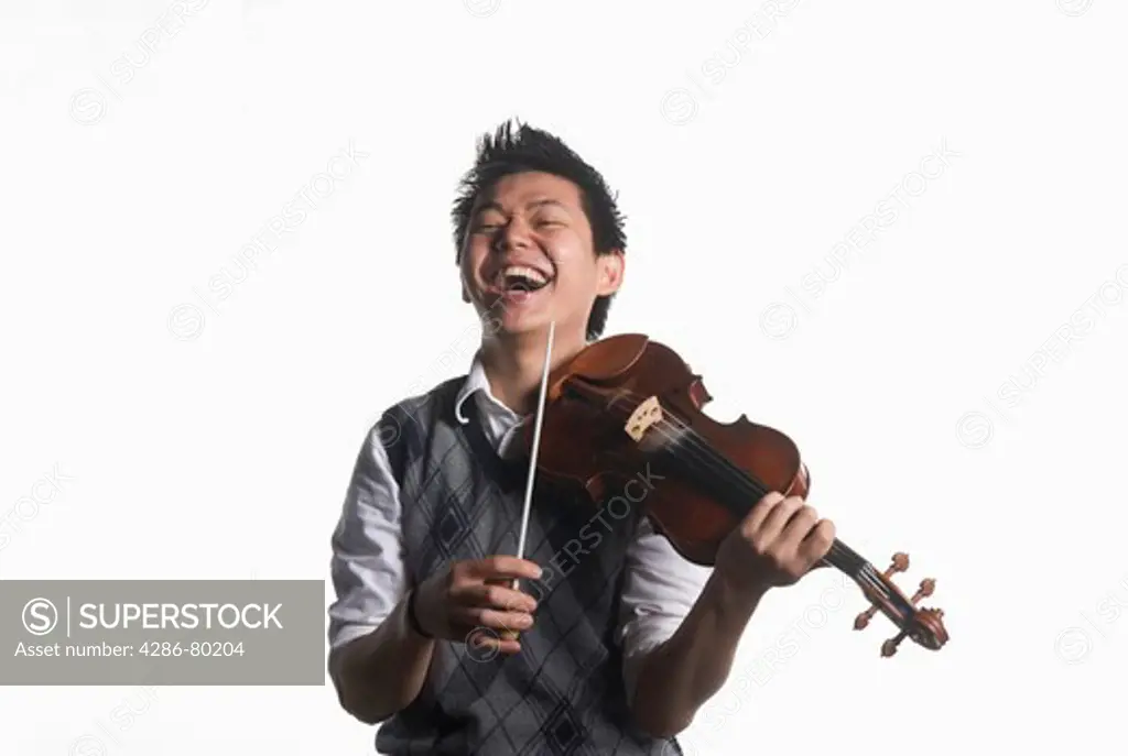 A college age man plays his violin and conducts. 