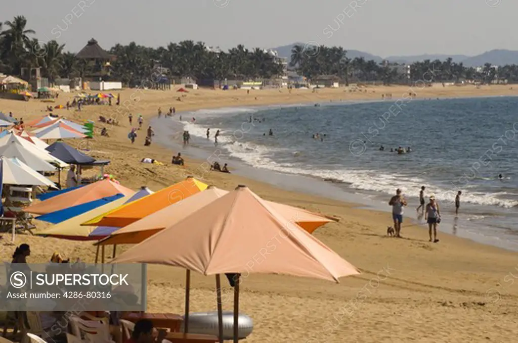 Umbrella filled shoreline and people enjoying the beach, Melaque Beach, Mexico