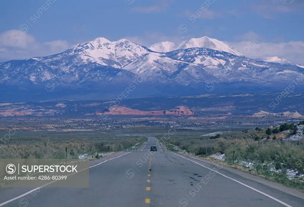 View of mountains rising behind the highway near Monticello, UT