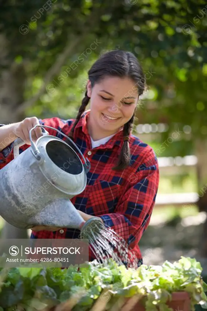 Teen Girl Watering Garden