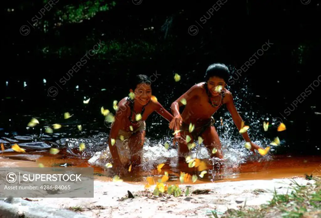 Munducur£ tribe girls chase butterflies in the sands of Rio Carur£, a tributary of the blue-water Rio Tapajos in Brazil.