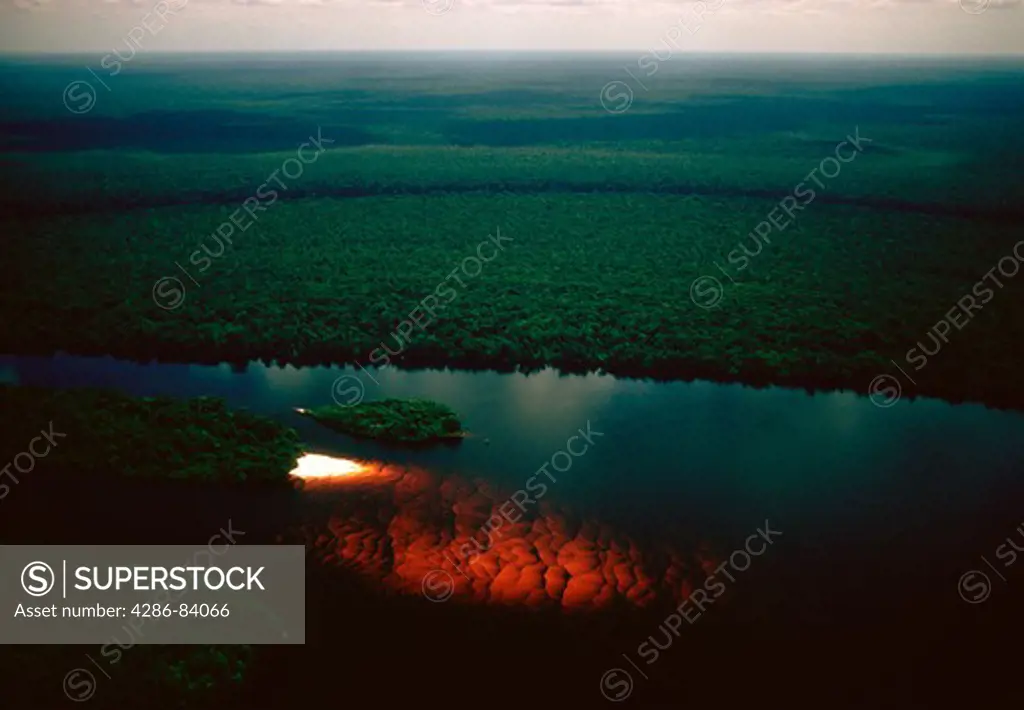 Aerial of the upper R¡o Negro, Brazil, showing the river's true colors when water stained by decaying vegetation flows over a white sand bar.
