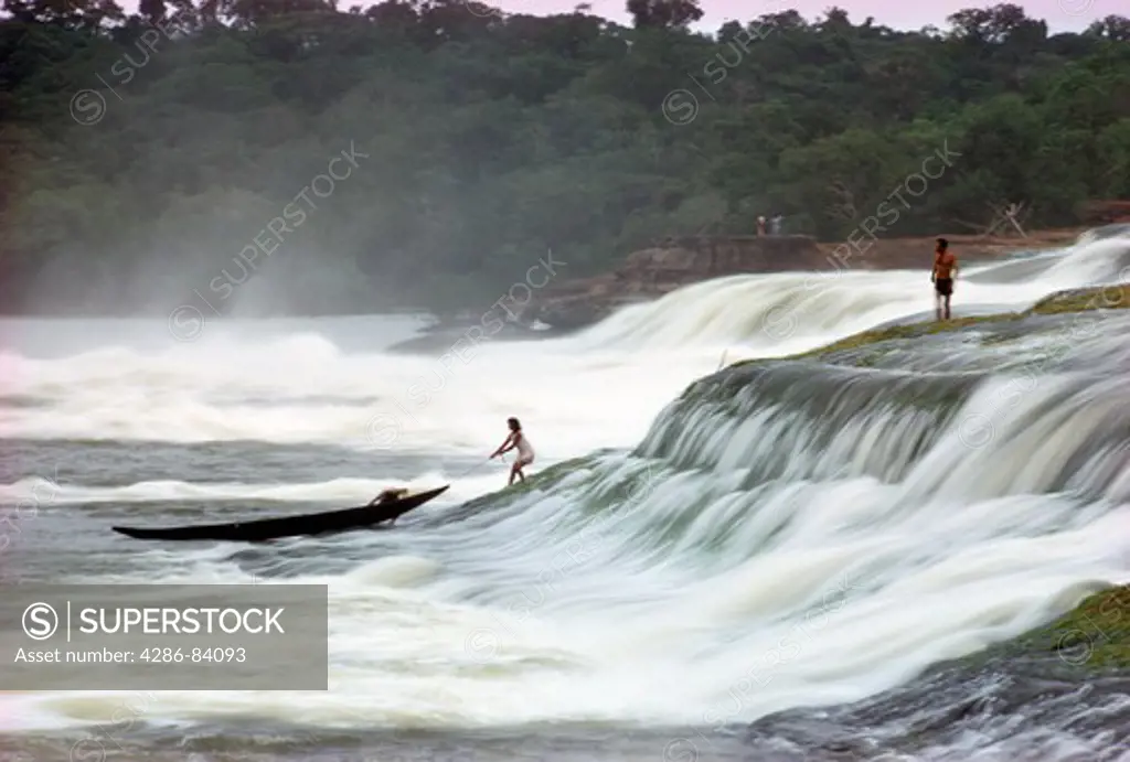 A Colombian family portages a dugout canoe up a cateract on the R¡o Vaups, a R¡o Negro tributary.