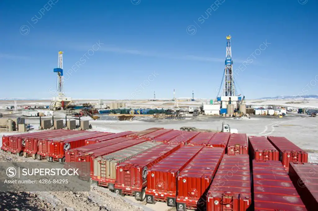 Water trailers near drilling rigs in Wyoming.