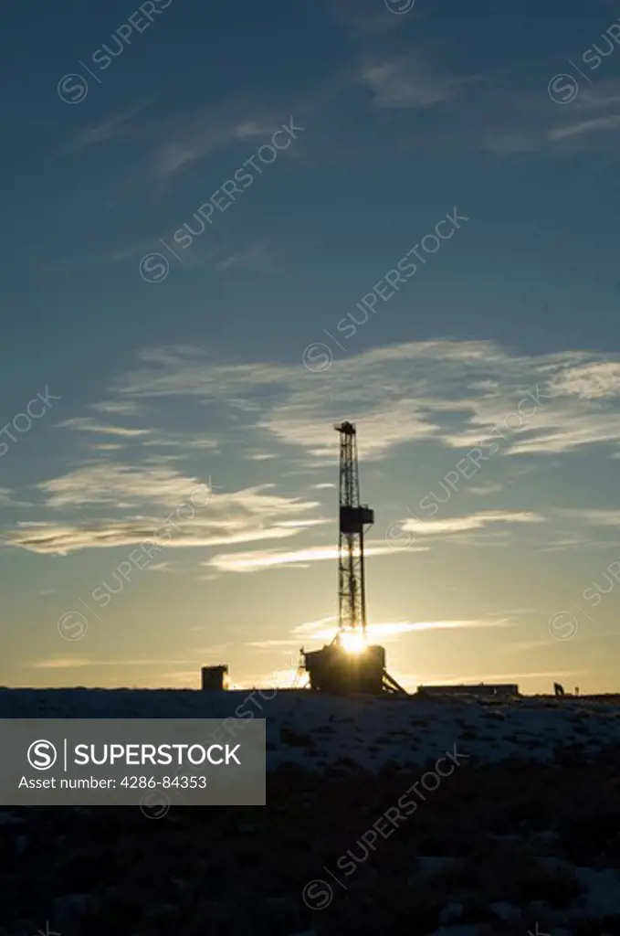 Wyoming sunset with drilling rig.