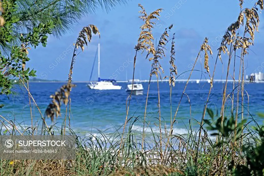 Sea oats and anchored boats beach Sanibel Island Florida