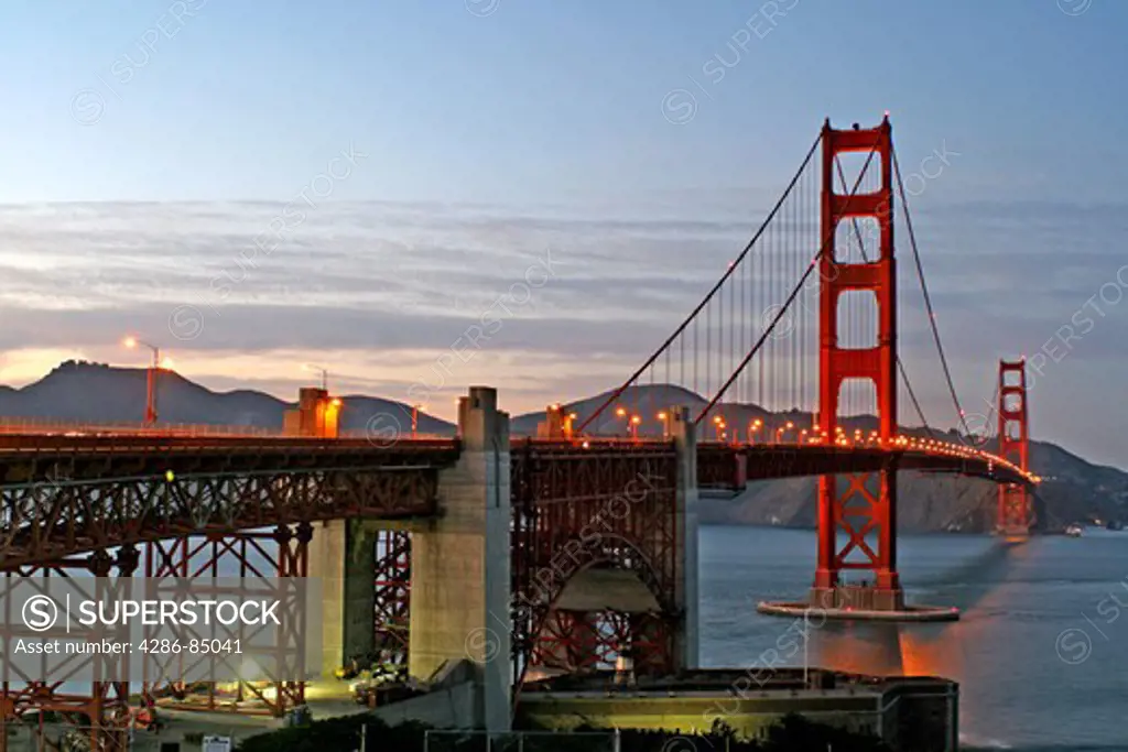 Overview of Golden Gate Bridge at dusk with Fort Point in the foreground looking north to Marin County San Francisco California