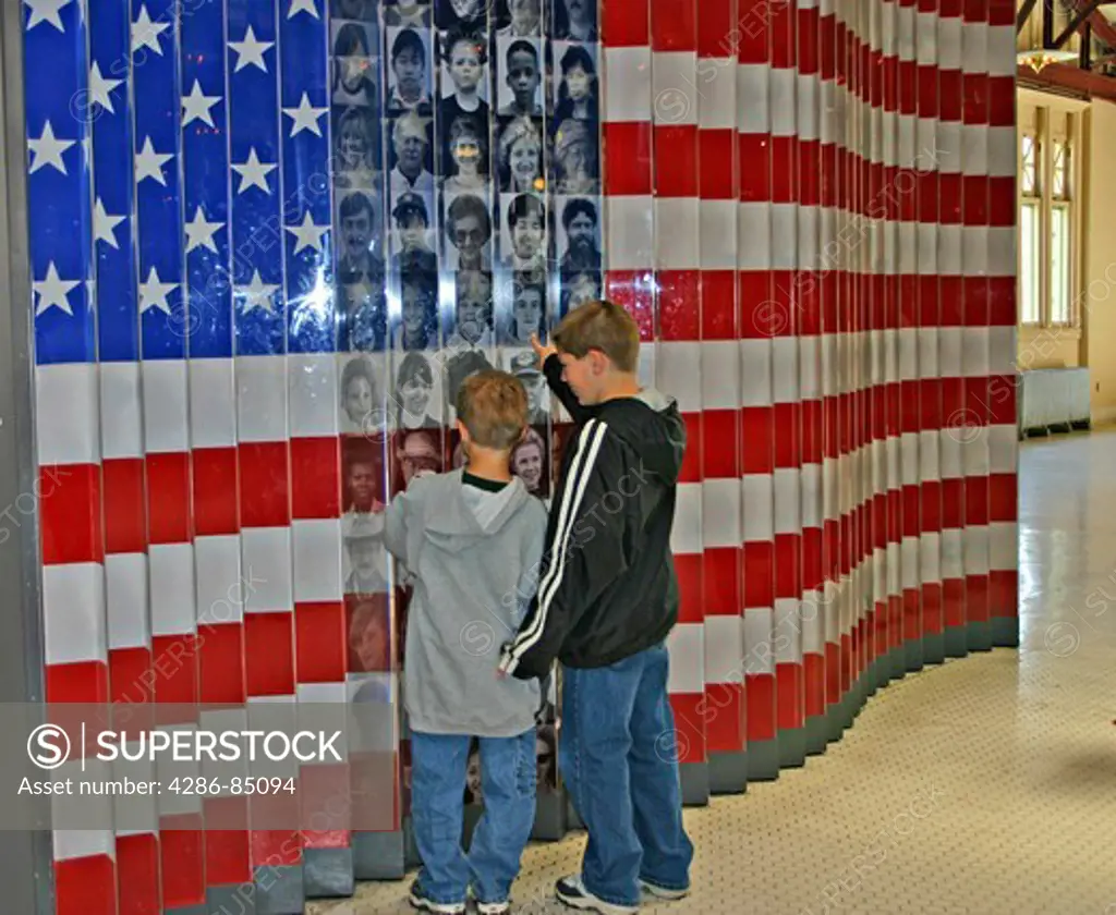 Boys at unique visual exhibit demonstrating US flag and immigrants at Ellis Island New York City
