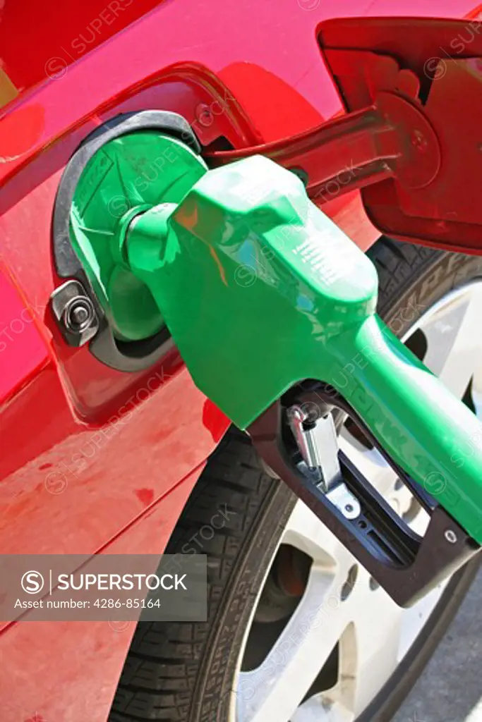 Bright green gas pump in red car