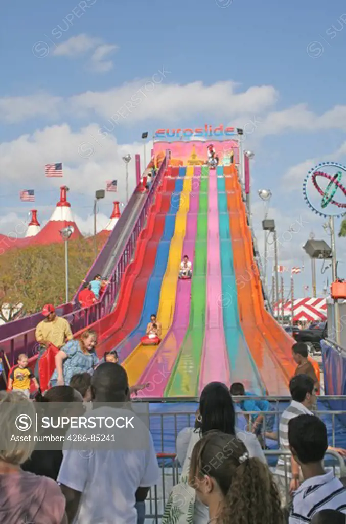 Ethnic kids down giant slide at Miami Dade County Fair Miami Florida
