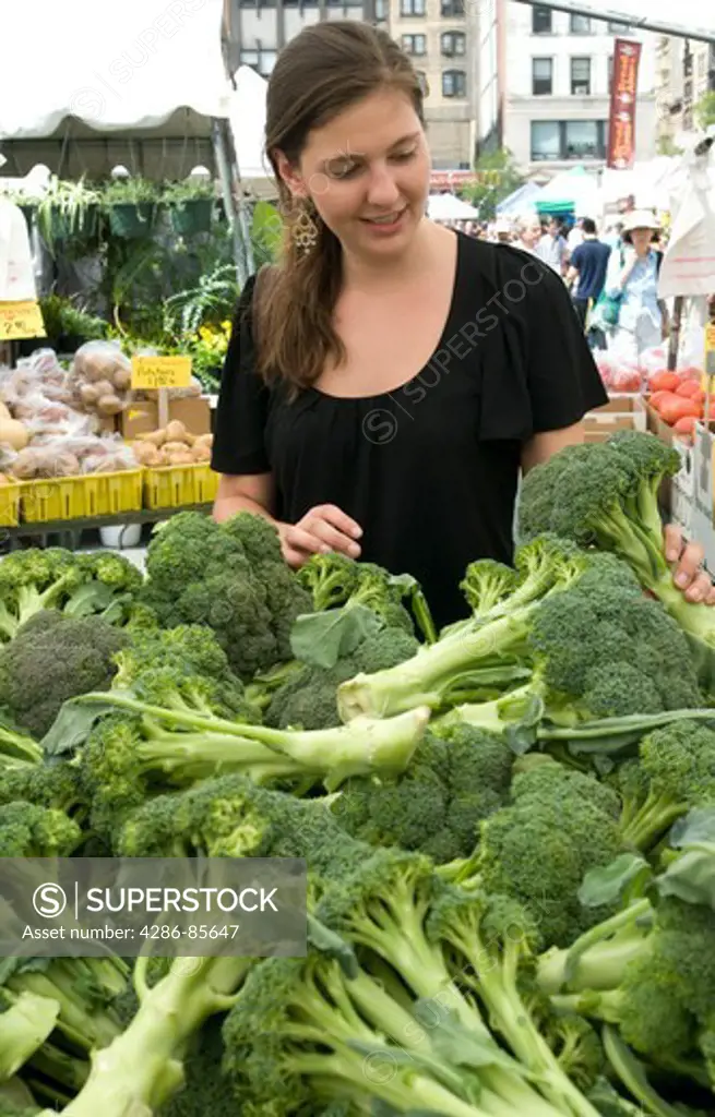 Union Square, NYC, 2009 - Young woman shopping for broccoli at an outdoor farmer's market Model Released -  Marty Heitner