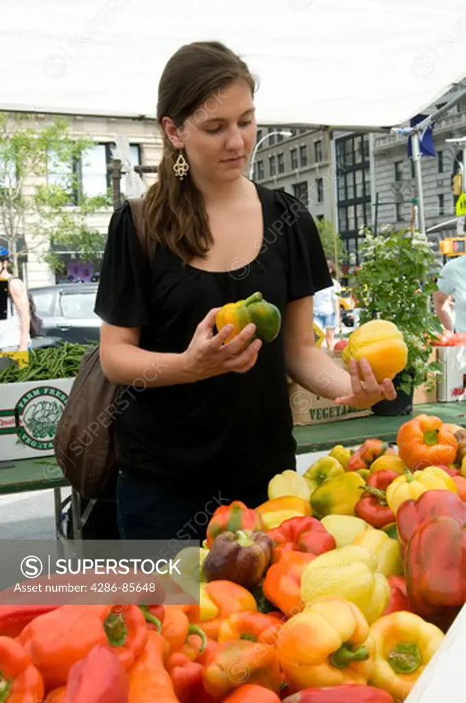 Union Square, NYC, 2009 - Young woman shopping for peppers at an outdoor farmer's market.  Model Released - Marty Heitner