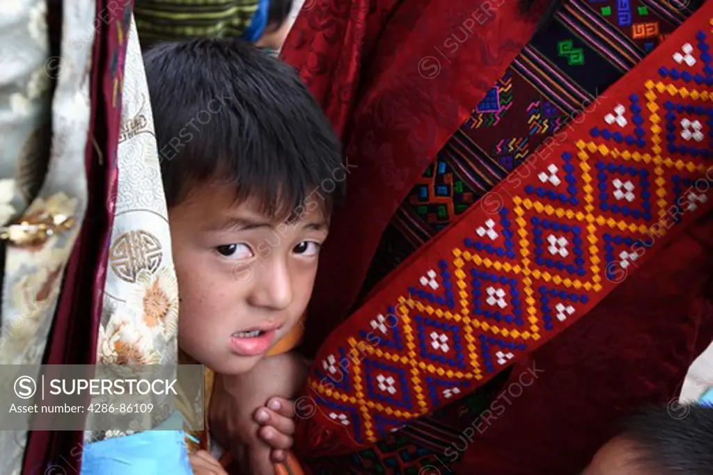 Child appearing between two women, Bhutan