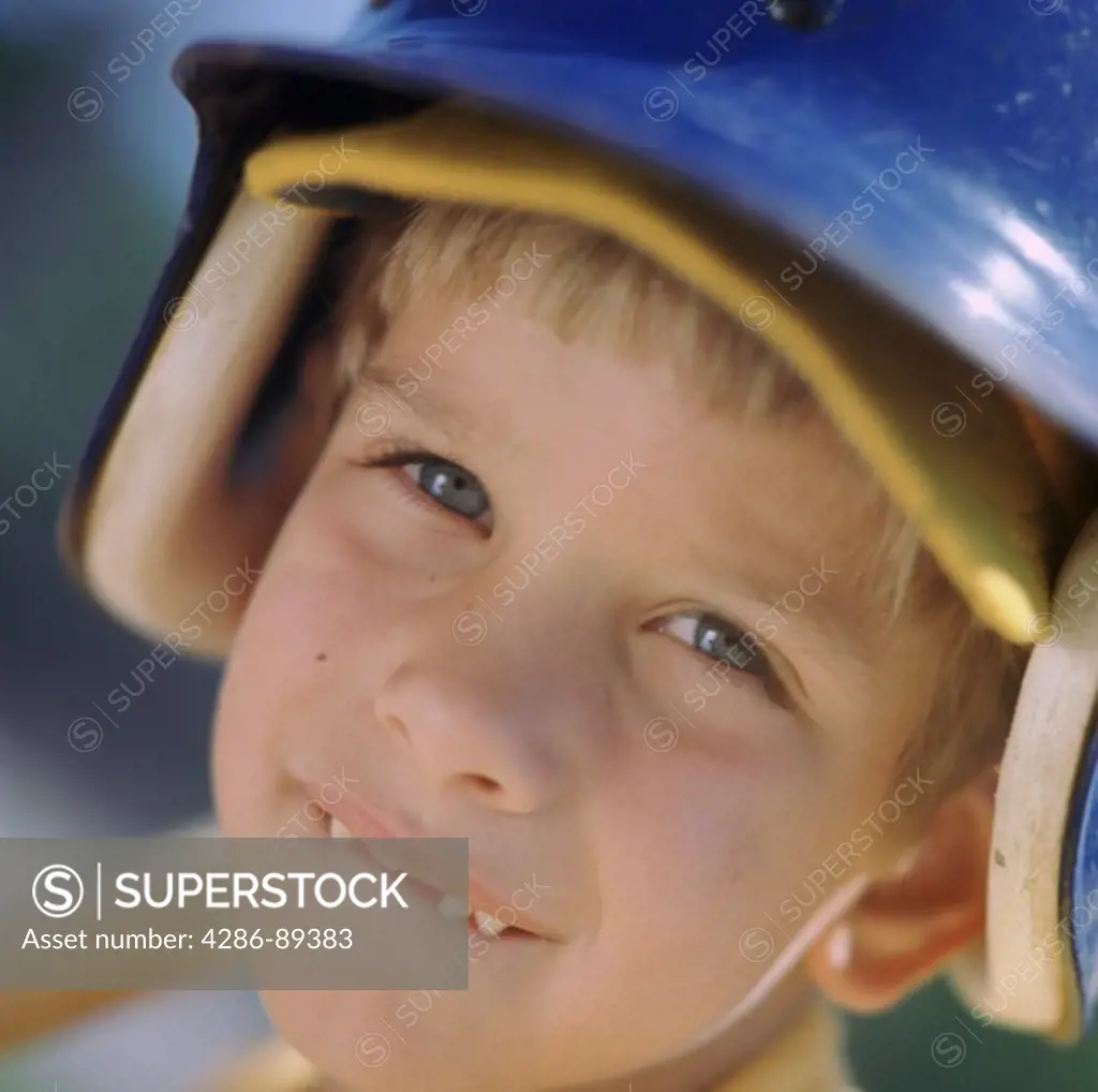 Close-up of a young boy wearing a basball batters helmet