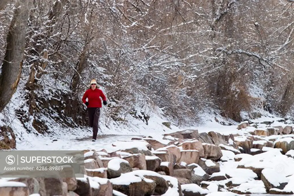 A female athlete runs along a trail in the foothills of the Rocky Mountains near Boulder, Colorado