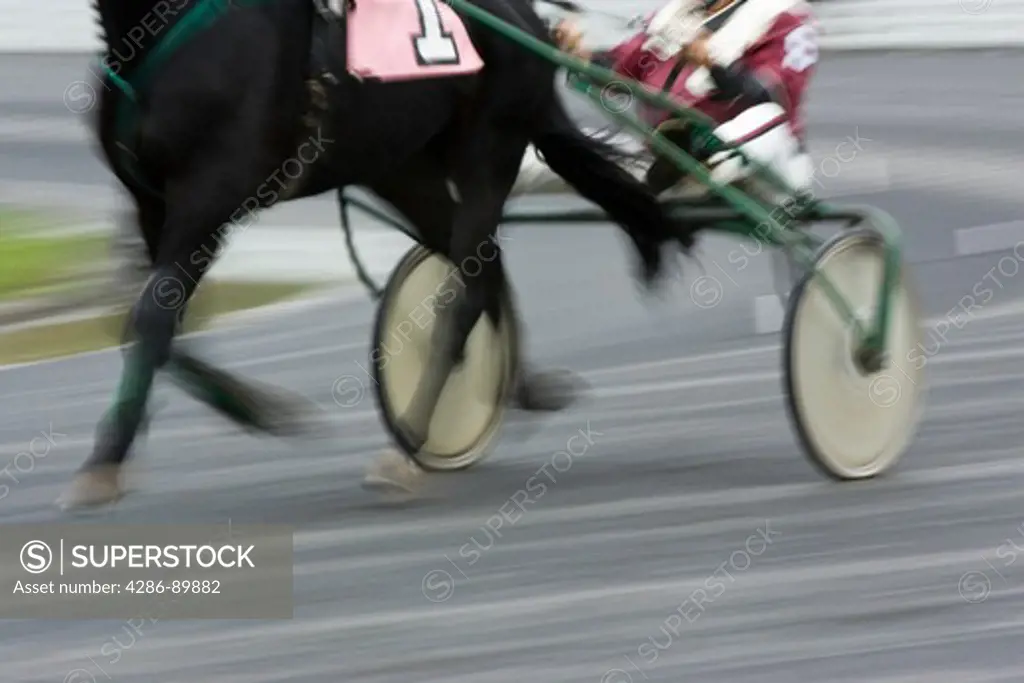 Horses and jockeys participate in harness racing during a rainy day in Monticello, New York.