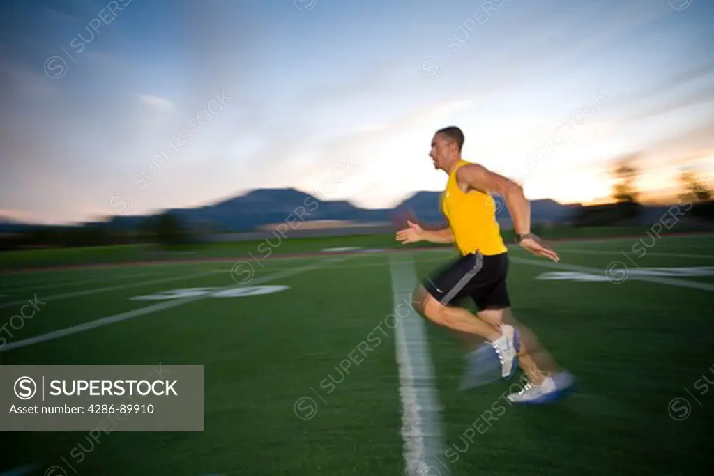 Athletes training by running and sprinting on a track field in Boulder, Colorado.