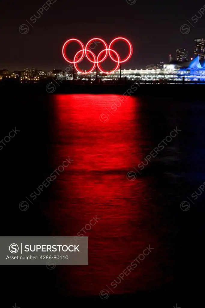 Red glowing Olympic rings refelcted in the harbour during the 2010 Winter Olympic Games, Vancouver, Canada
