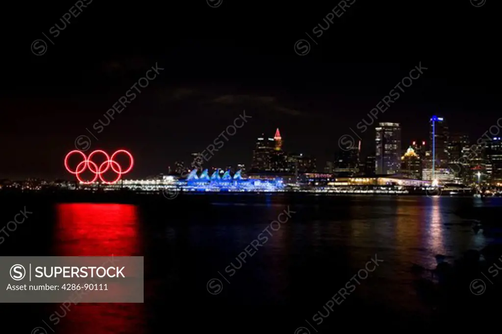 Red glowing Olympic rings, Canada Place and media center along the waterfront during the 2010 Winter Olympic Games, Vancouver, Canada