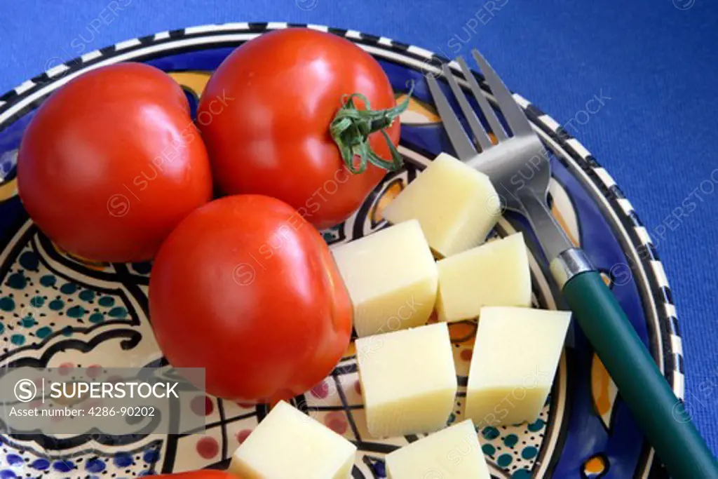 Greek Food. Fresh Tomatoes and segments of a light cheese from Macedonia, Kefalogravier