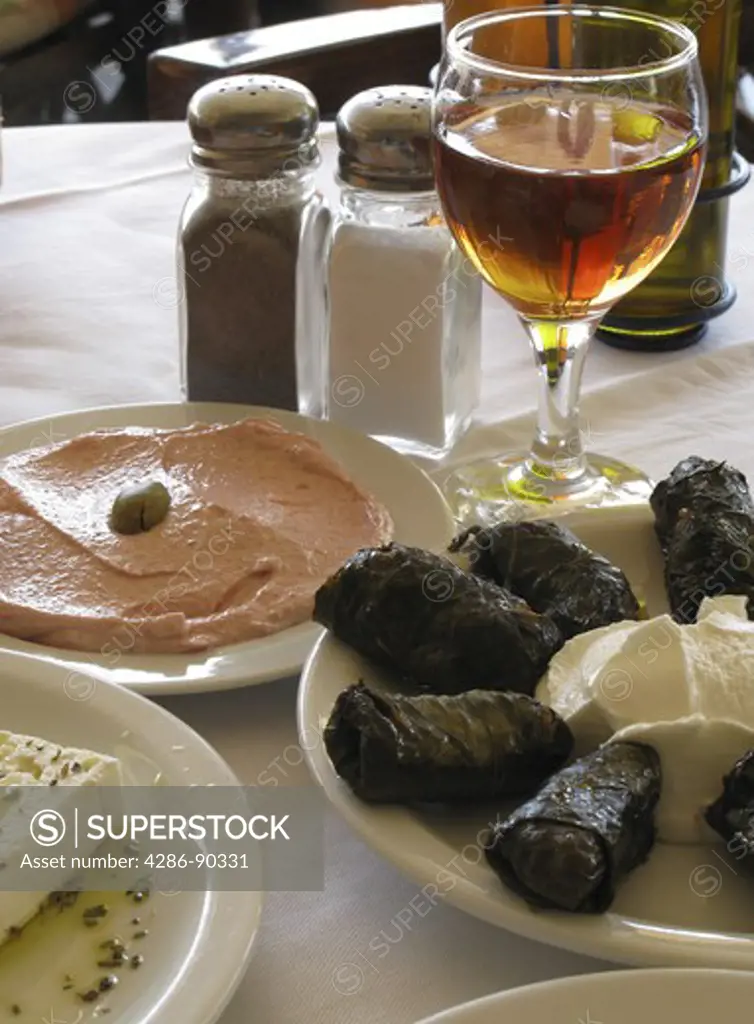 Greek Cuisine. Taramasalata, Dolmades, Feta cheese, and glass of red wine. Chania, Crete, Greece
