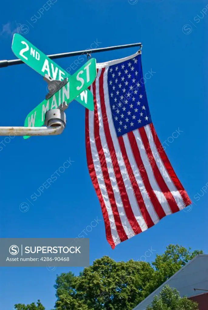 American flag and Main Street sign on blue sky summer day, Perham, Otter Tail County, Minnesota, USA