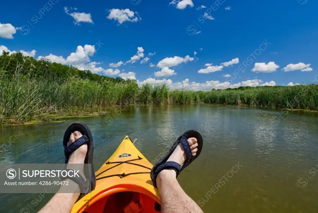 Kayaker leisurely floats through wetland on Otter Tail River, Perham, Minnesota