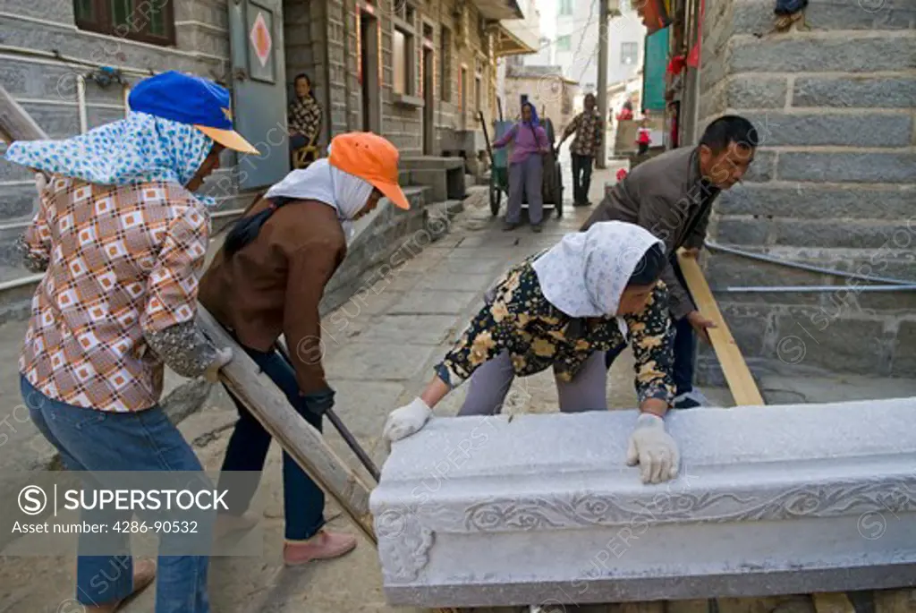 Working as team, men and women workers roll stone carving, Quanzhou, Fujian Province, China