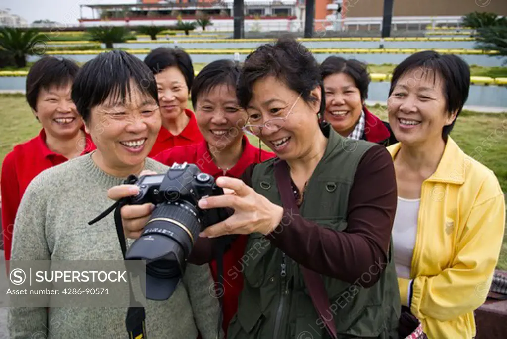 Domestic tourist shares digital photograph with women, Yueqing, Zhejiang Province, China