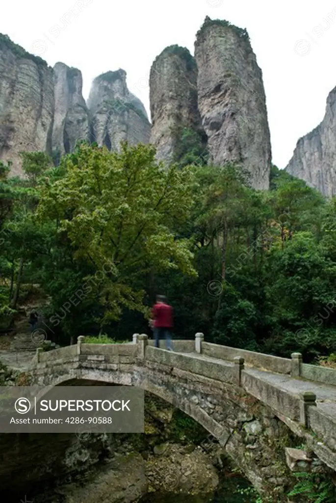Stone bridge crosses dry creek under soaring mountains, Yangdang Mountains, Wenzhou, Zheijiang Province, China