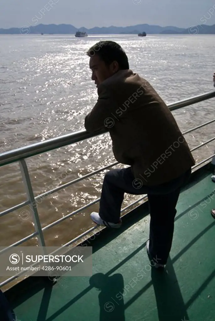 Man on ferry boat wathces the sea, Zhoushan, Zhejiang Province, China