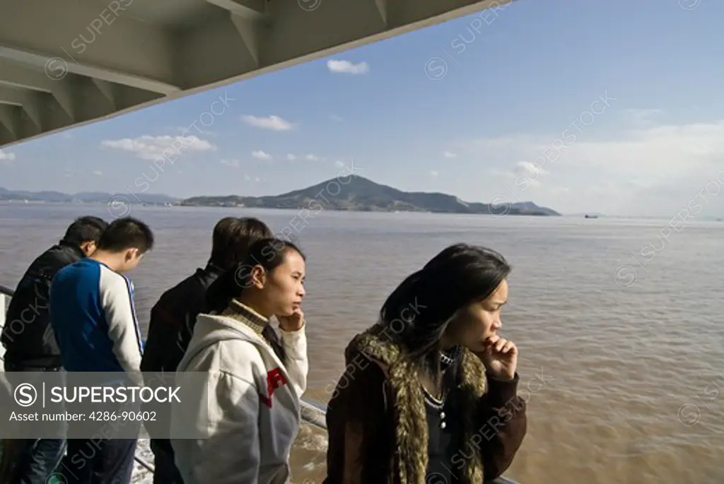Young women watch the sea from ferry boat,  Zhoushan, Zhejiang Province, China