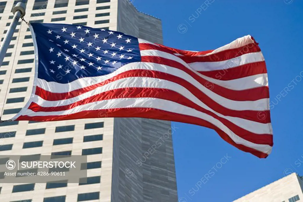 American flag ripples in wind below highrise downtown buildings, Miami, Florida