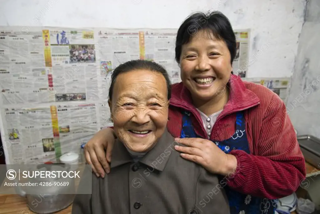 Mother, left, Chen Xia Hua,is hugged by daughter Liu Sai Jun in kitchen of family run restaurant, Zhujijian Village, Zhoushan Archipelago, Zhejiang Province, China