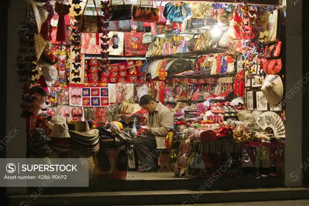 Souvenir shopkeeper late at night in historic water town, Zhouzhuang, Jiangsu Province, China