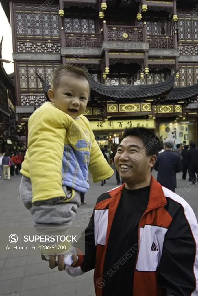 Father pridefully balances son on one hand, Yuyuan Gardens and Bazaar, Shanghai, China