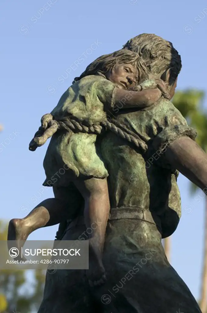 Statue depicting historic ship salvager rescuing child on his back at Mallory Square, Key West, Florida