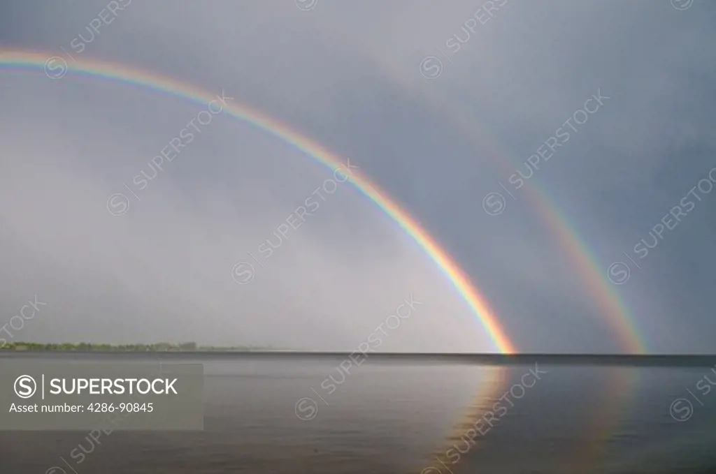 Rainbow breaks through rain storm at sunset, Big Pine Lake, Minnesotta