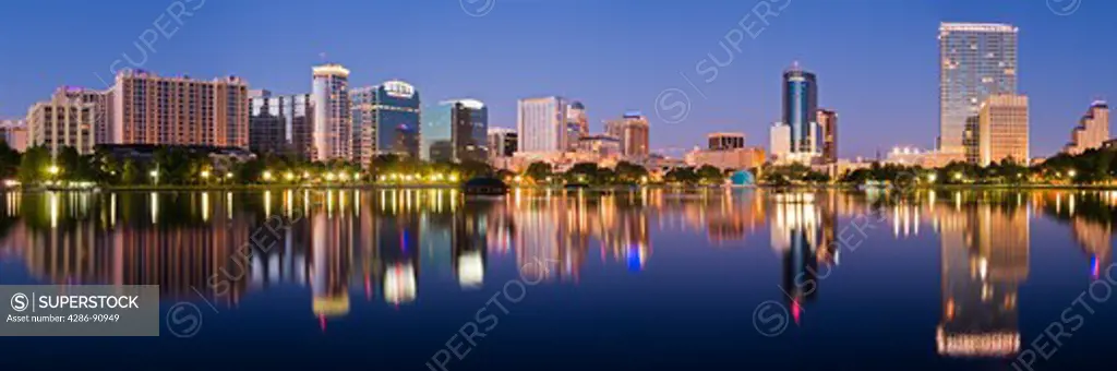 Glowing nighttime downtown skyline of Orlando, Florida, reflects in Lake Eola