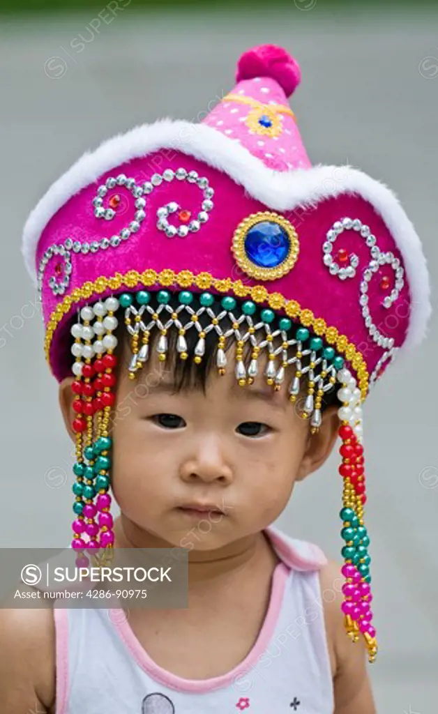 Young girl dressed in fancy costume hat, Tiatan Park, Beijing, China